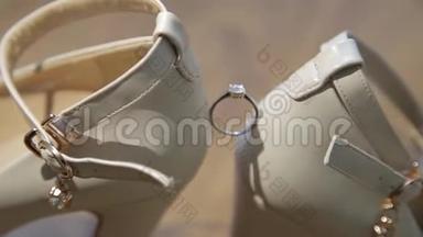 结婚戒指在女人`白鞋上。 新娘白鞋上漂亮`结婚戒指。 白色婚礼订婚